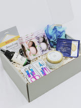 Curated Gift Box for her, including a detoxifying face mask, face spray, travel nail kit, candle, 2 eye masks, lufa and four bath bombs.