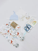 Curated Baby Git Box includes pair of shoes, socks, muslin wrap, book, beanie, onesie, teether, and stuffed animal blanket.