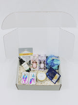 Curated Gift Box for her, including a detoxifying face mask, face spray, travel nail kit, candle, 2 eye masks, lufa and four bath bombs.