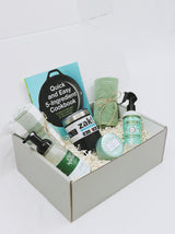 Curated gift box for new home or apartment, including kitchen towels, foaming soap, room spray, Voluspa candle, coffee tumbler, and cook book